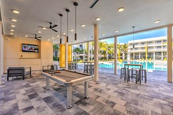 A pool table in a room with a large window
