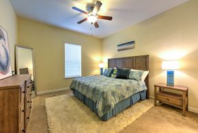 Jacksonville apartment for rent - A bedroom with a bed, dresser, and ceiling fan at Alaqua, Florida, 32258