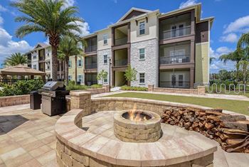 A fire pit with a grill in front of an apartment building
