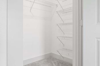 A small closet with white walls and a white door