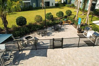 A patio with a grill and tables and chairs