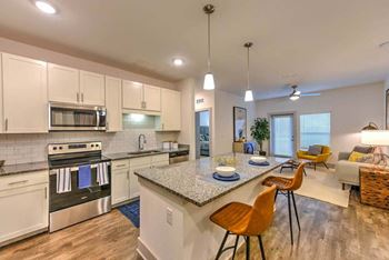 A kitchen with a counter top next to a stove top oven