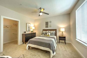 A bedroom with a bed and a ceiling fan