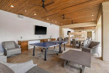 A room with a ping pong table and chairs