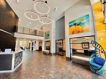 A lobby with a blue chair and a yellow wall