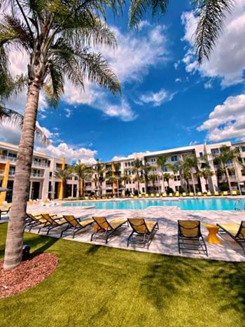 A swimming pool with a bunch of chairs next to it