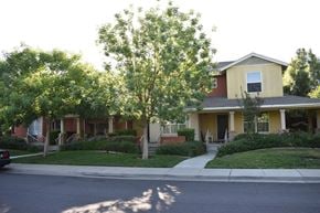 Davis townhouse for rent - A yellow house with a tree in front of it.