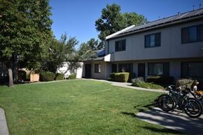 Davis townhouse for rent - A bicycle is parked on the grass in front of a building.