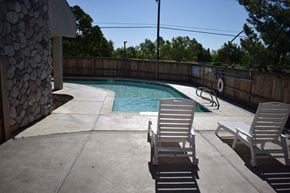 Davis townhouse for rent - A pool with two chairs and a stone wall.