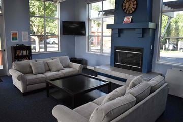 Davis townhouse for rent - A living room with a grey couch, a black coffee table, and a blue fireplace.