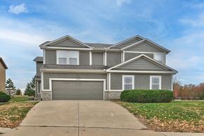 Olathe triplex for rent - a house with a driveway and a garage door