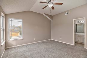 Olathe triplex for rent - an empty bedroom with a ceiling fan and a window