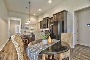 Gardner triplex for rent - A modern dining room with a black table and wicker chairs.
