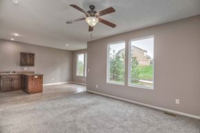 Olathe triplex for rent - an empty living room with a ceiling fan and a window