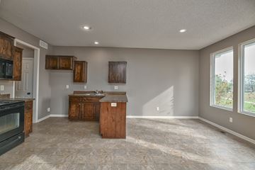 Olathe triplex for rent - A kitchen with a black oven and wooden cabinets.