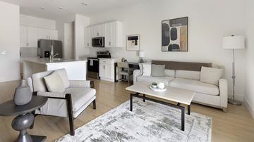 Tucson apartment for rent - A modern living room with a grey rug and a white sofa.