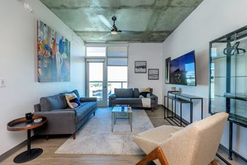 Tucson apartment for rent - A living room with a grey couch and a wooden chair.