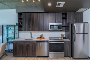 Tucson apartment for rent - A modern kitchen with dark wood cabinets and stainless steel appliances.