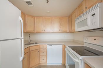 A kitchen with white appliances and wooden cabinets