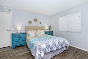 Tucson apartment for rent - A bedroom with a blue bed and a white wall.