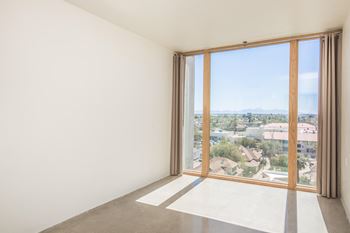 A room with a large window overlooking a residential area