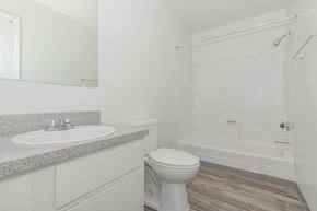 Tucson apartment for rent - A white bathroom with a toilet, sink, and bathtub.