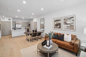 Denver apartment for rent - A modern living room with a brown couch and a coffee table.