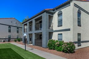 Tucson apartment for rent - A building with a red tile roof and a balcony with a railing.