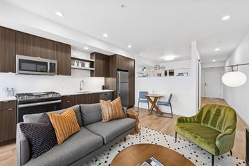 Portland apartment for rent - A modern living room with a grey couch and a green armchair.