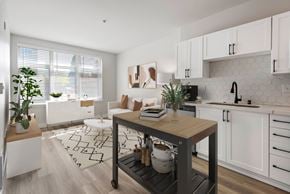 Seattle apartment for rent - A kitchen with white cabinets and a wooden island.