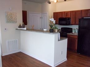 Dickinson apartment for rent - A kitchen with a white island and wooden cabinets.