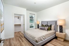 Santa Ana apartment for rent - A bedroom with a large bed and a nightstand with a lamp.