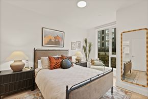 Bend apartment for rent - A bedroom with a large bed and a painting of two horses on the wall.