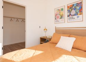Gresham apartment for rent - Arts Plaza Gresham Oregon Apartments A bedroom with a bed, a nightstand with a lamp, and two framed pictures on the wall.
