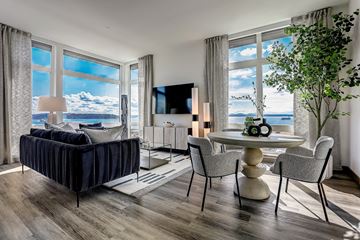 Seattle apartment for rent - a living room with a view of the ocean and a table and chairs