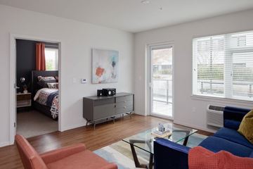 Portland apartment for rent - A living room with a blue couch and a red chair.