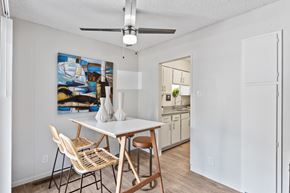 Reno apartment for rent - A dining room with a table and chairs and a painting on the wall.