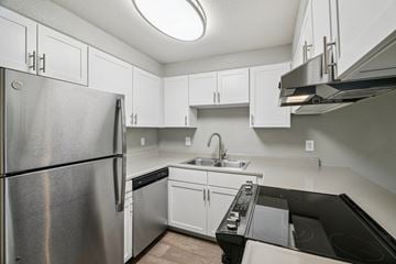 Gresham apartment for rent - A kitchen with a stainless steel refrigerator and black countertops.