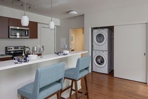 Portland apartment for rent - A modern kitchen with a blue chair and a washing machine.