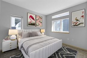 Tacoma apartment for rent - A bedroom with a large bed, two nightstands, and two framed pictures on the wall.