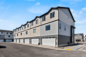 Pleasant Grove apartment for rent - A modern two-story building with a garage door is situated in a parking lot.