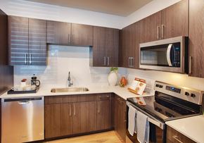Aurora apartment for rent - A modern kitchen with wooden cabinets and stainless steel appliances.