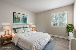 Murrieta apartment for rent - Murrieta, CA, Apartments for Rent - Waterstone at Murrieta - Spacious Bedroom With White Bedding, Wood Nightstands, Lamps, Wall Art, Large Window With Blinds, and Soft Neutral Walls.