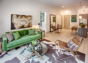 Denver apartment for rent - A living room with a green couch and a glass coffee table.