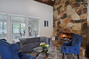 Holladay apartment for rent - A living room with a stone fireplace and blue chairs.