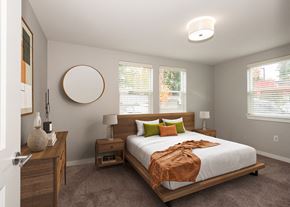 Vancouver apartment for rent - A bedroom with a bed, nightstands, and a round mirror on the wall.