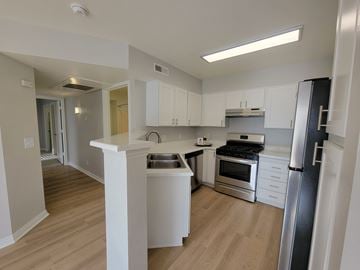 Draper apartment for rent - A kitchen with white cabinets and a wooden floor.