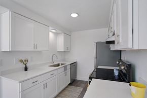 Layton apartment for rent - A kitchen with white cabinets and a black stove top oven.