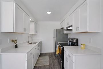 Layton apartment for rent - A kitchen with white cabinets and a black refrigerator.