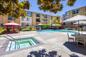 Pleasant Hill apartment for rent - A pool area with a red gazebo and a table with chairs.